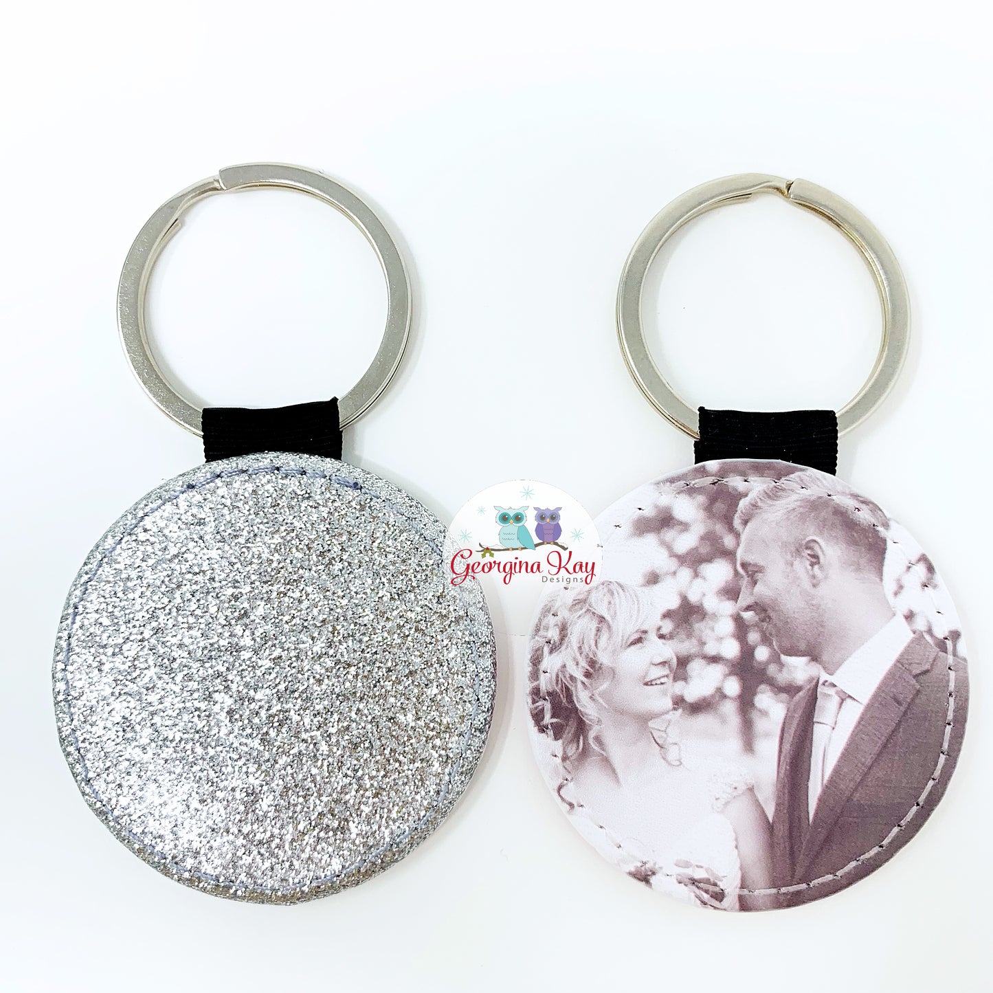 Two keychains, one glittery and one with a printed image of a couple, on a white background.
