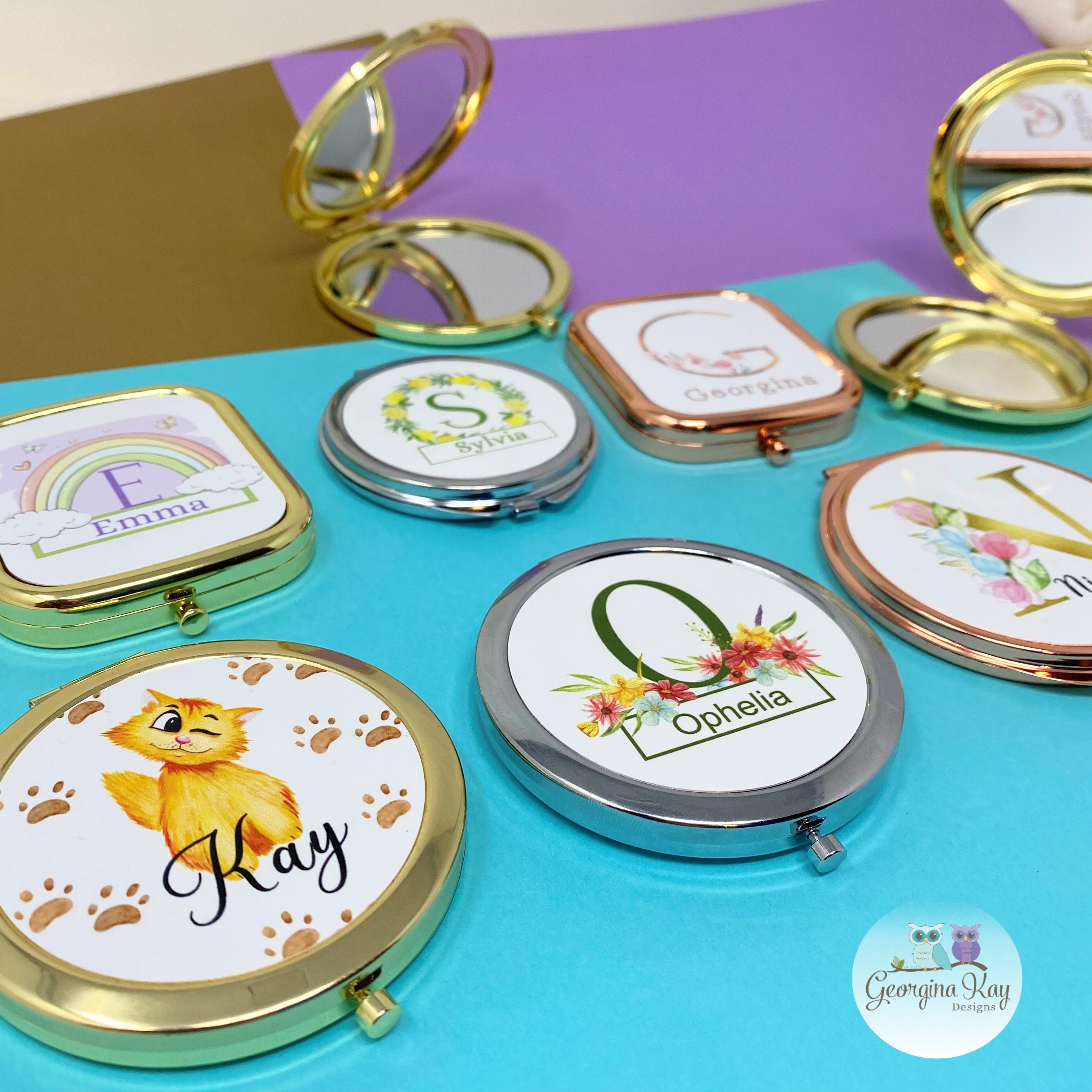 a flat lay of 8 pocket mirrors in gold, silver and rose gold. Each has a different name -  Kay, Ophelia, Emma, Sylvia, Georgina