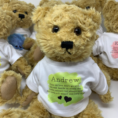 Teddy bear wearing a shirt with text and a small blue toy inside, on a white background