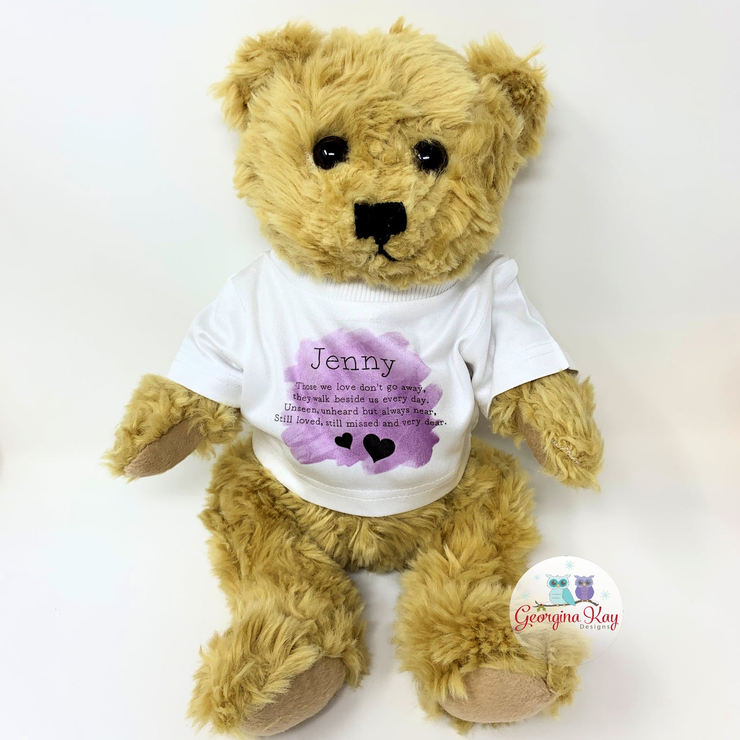 Teddy bear wearing a white t-shirt with text and a purple heart design on a white background