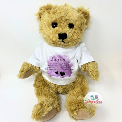 Teddy bear wearing a white t-shirt with text and a purple heart design on a white background
