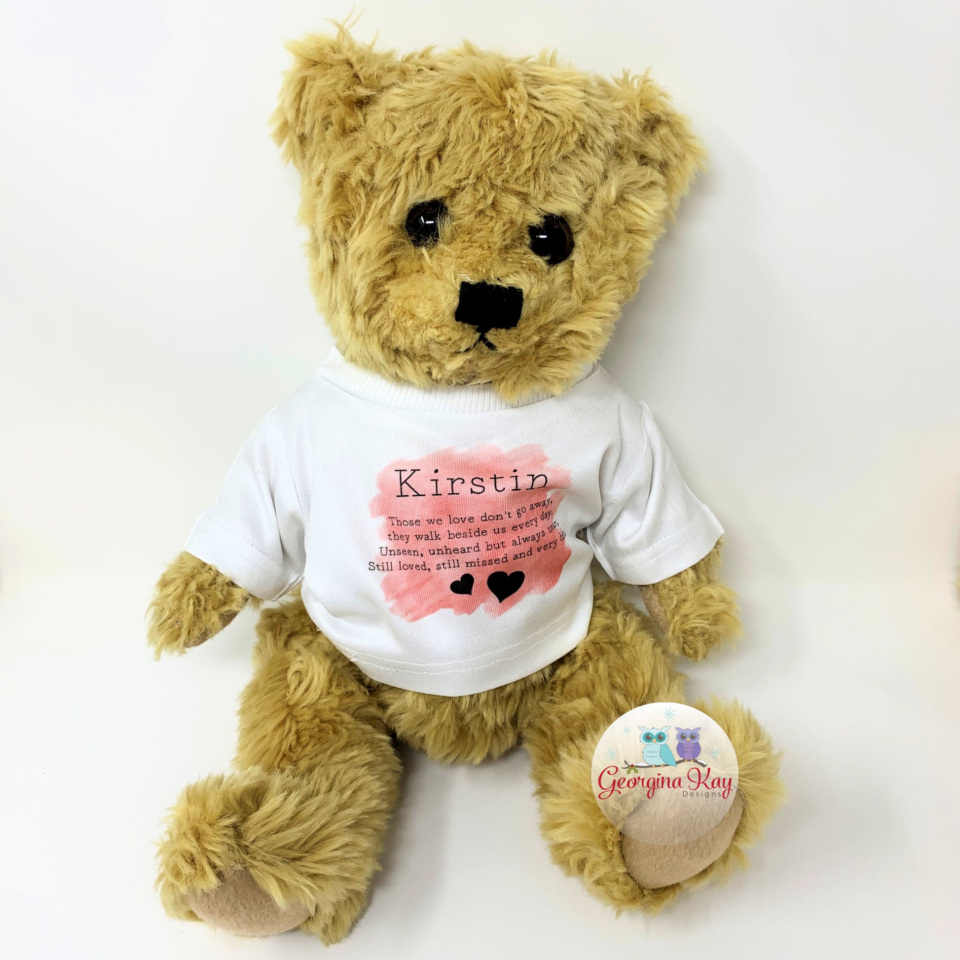 Teddy bear wearing a white t-shirt with text and a heart design, on a white background.