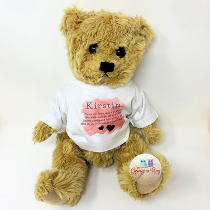 Teddy bear wearing a white t-shirt with text and a heart design, on a white background.