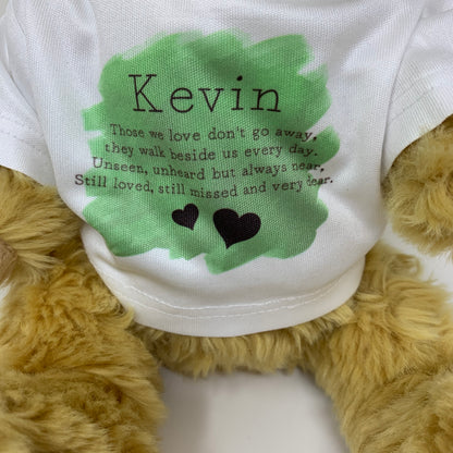 Plush teddy bear wearing a shirt with text and 'Kevin' printed on it.