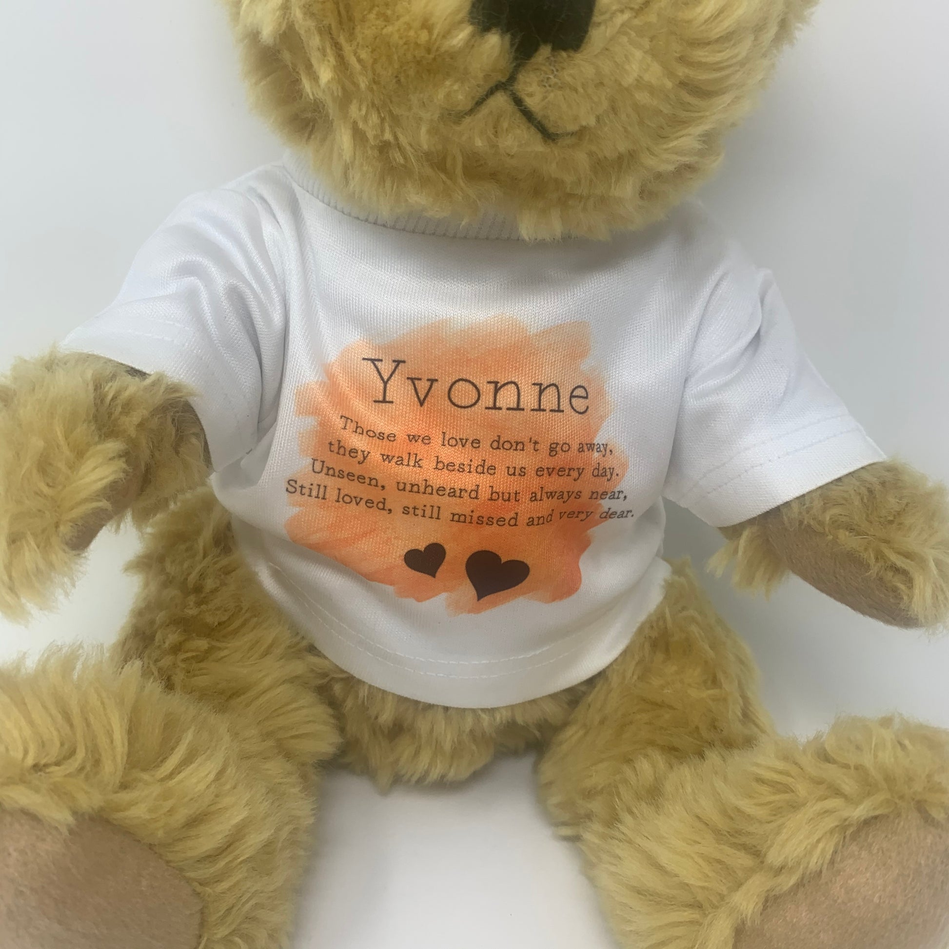 Teddy bear wearing a white shirt with text and a heart design on a white background