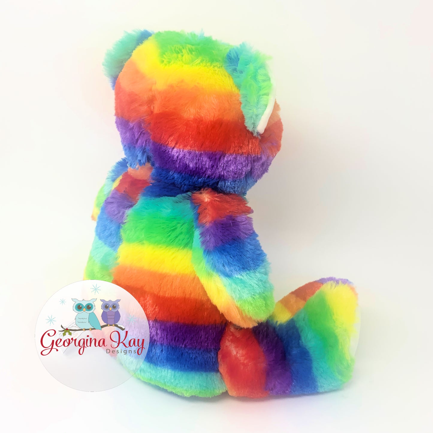 Rainbow-colored teddy bear with a white background and Georgina Kay logo.