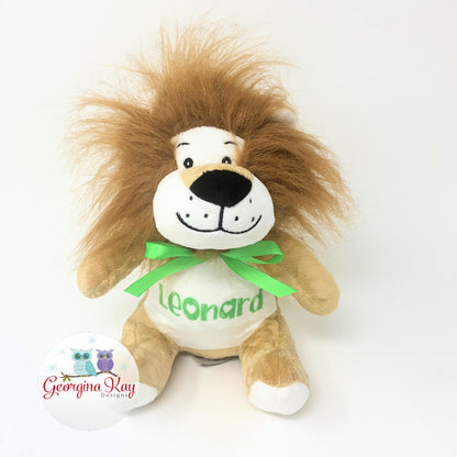 Plush lion toy with a green bow and 'Leonard' on a white background, branded with 'Georgina Kay'.