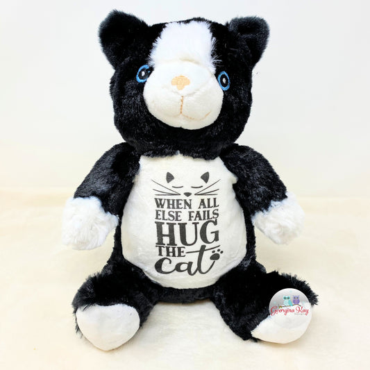 Black and white plush toy with a message on its chest against a light background