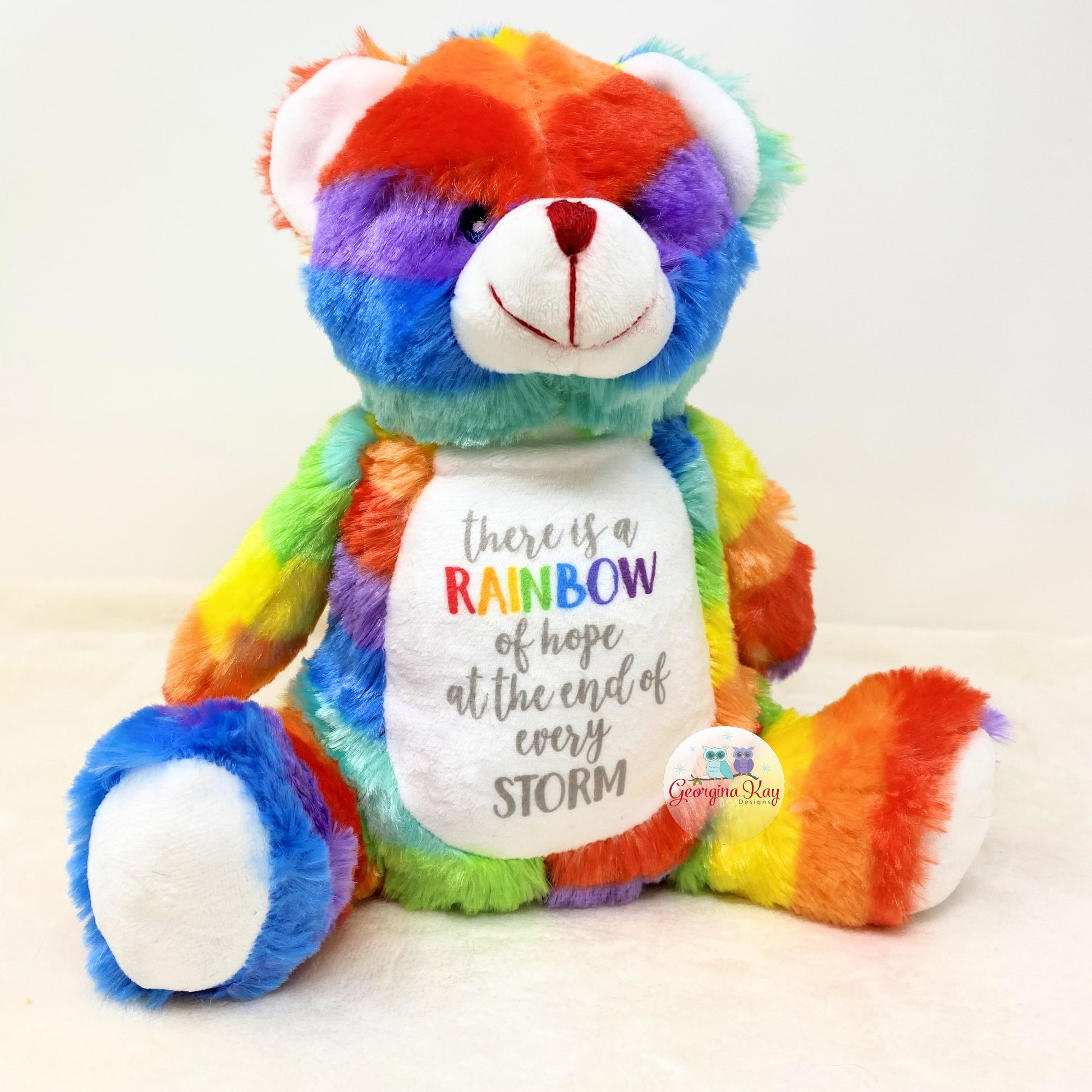Rainbow-colored teddy bear with a motivational message on a white background