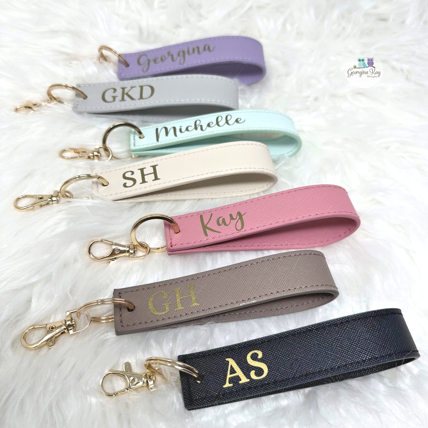 Set of personalized keychains with names and initials on a soft white background