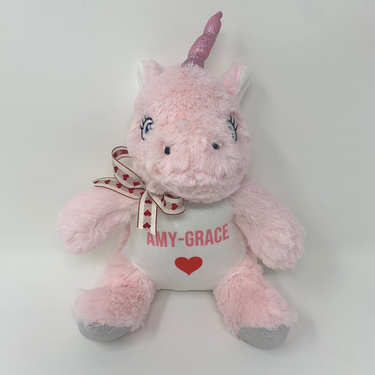 Pink plush unicorn toy with 'Amy-Grace' and a heart on a white background