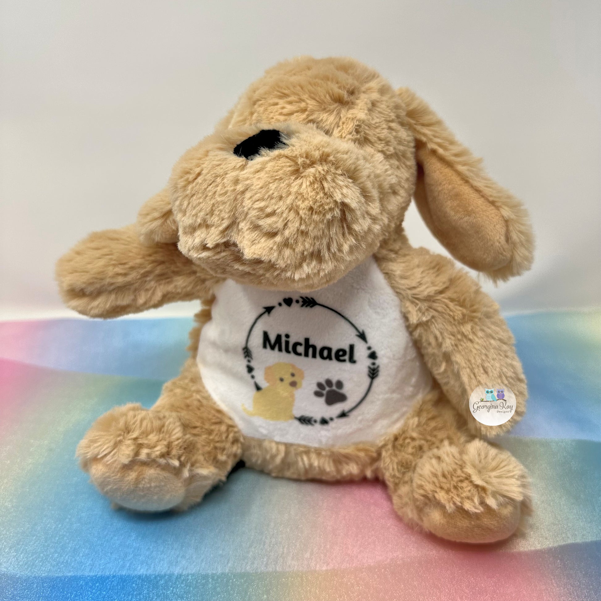 Plush dog toy with a shirt labeled 'Michael' on a colorful blanket