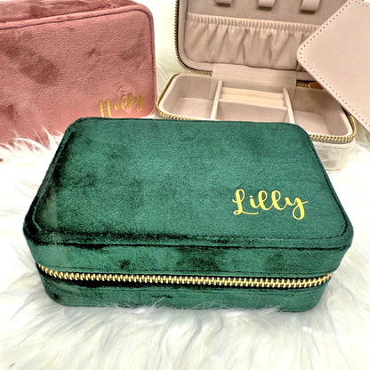 Green velvet jewelry box with 'Lilly' branding on a fluffy white surface.