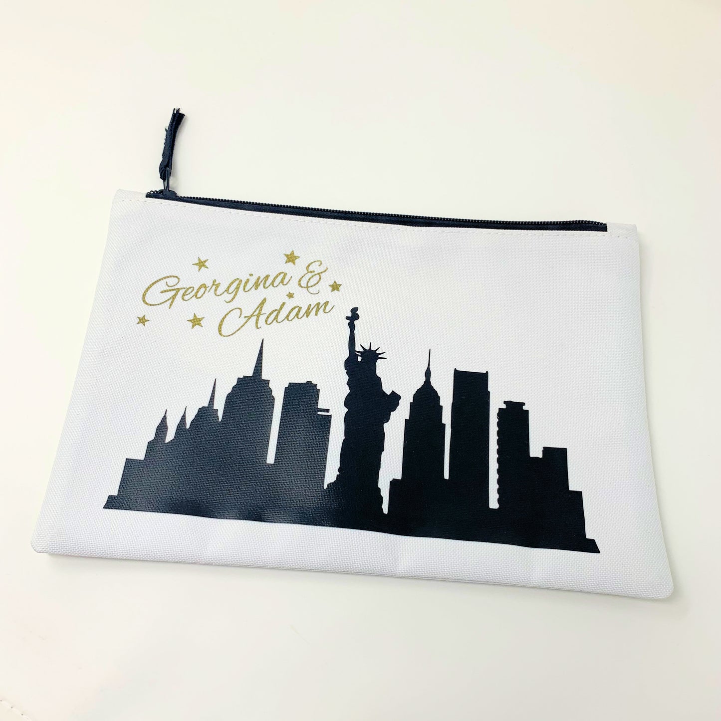 Pouch with New York City skyline silhouette and personalized names on a white background