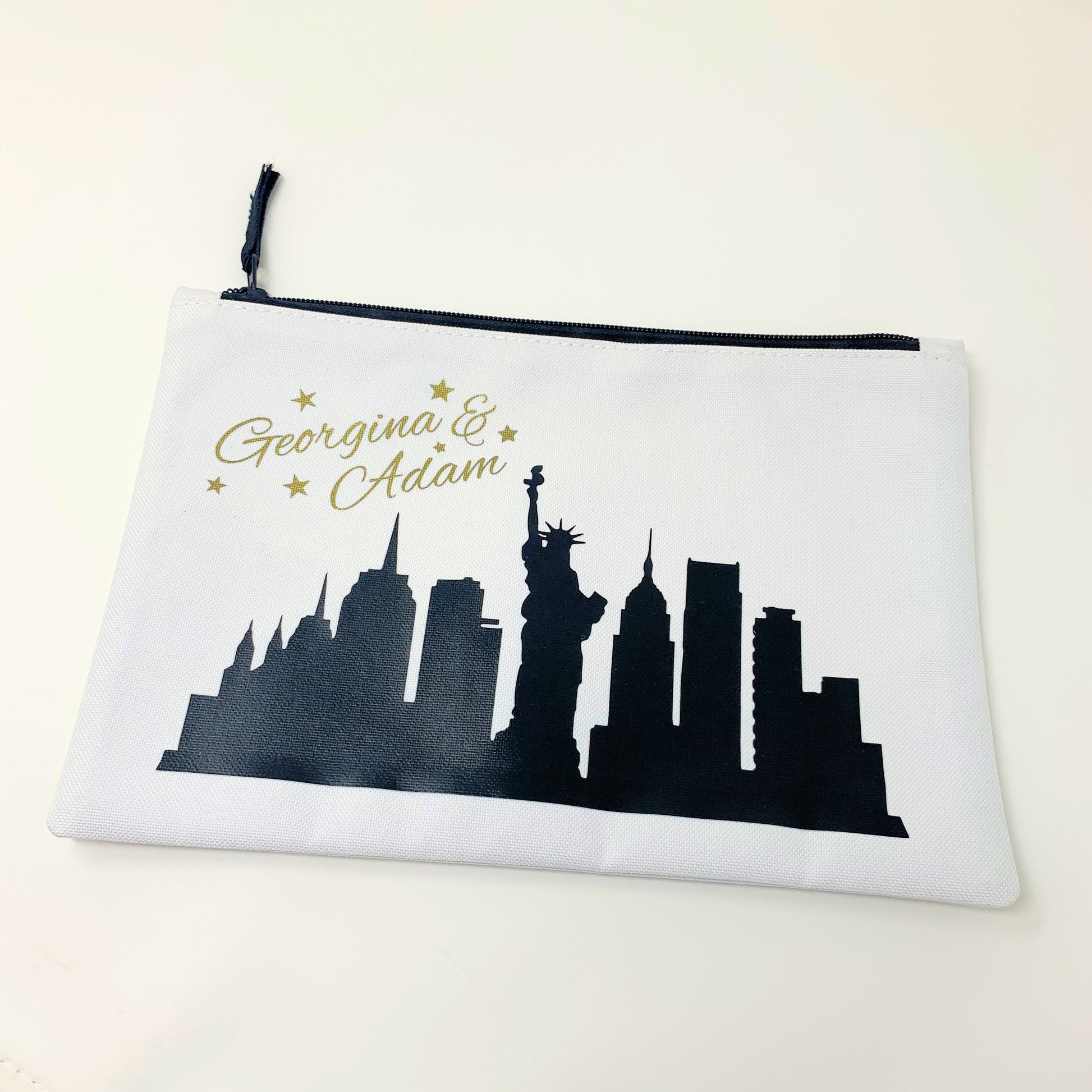 Pouch with New York City skyline silhouette and personalized names on a white background