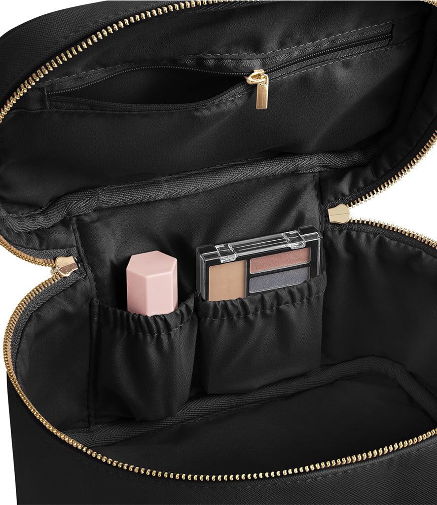 Black makeup bag with gold zipper and compartments containing cosmetic products.
