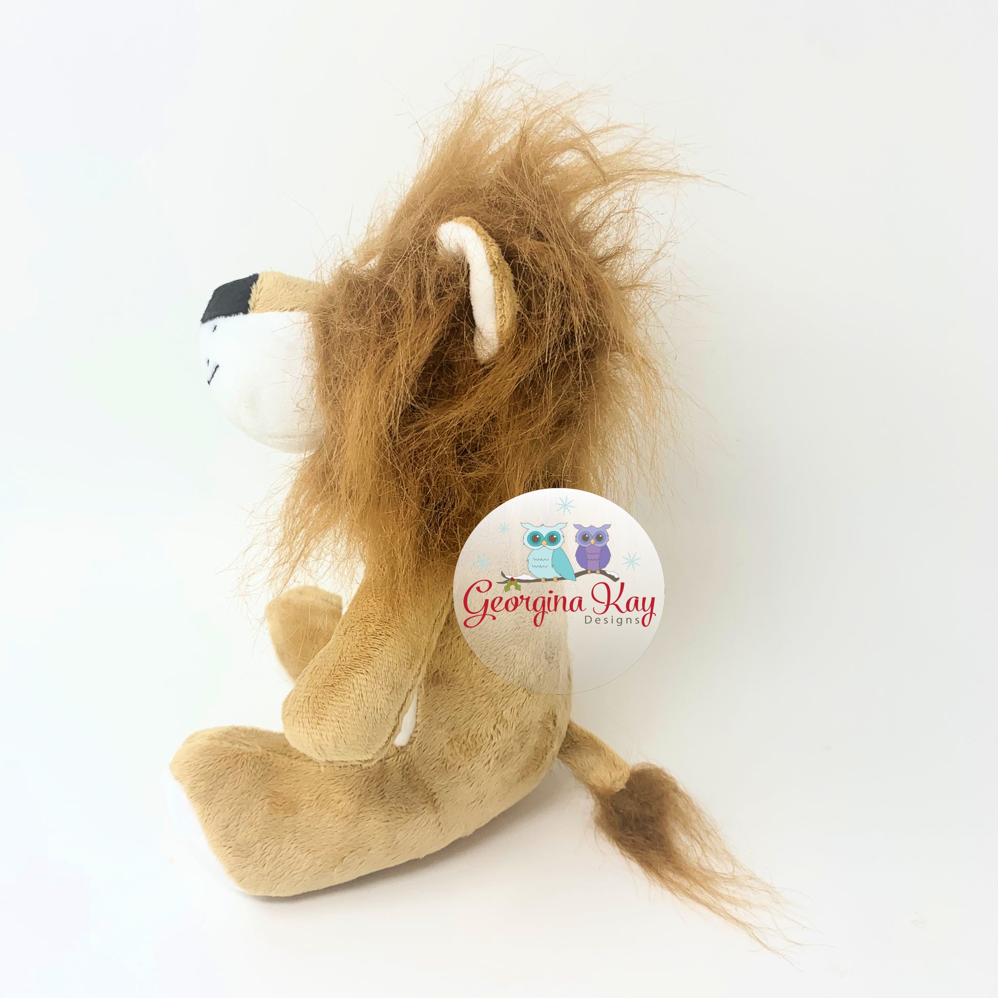 Plush lion toy with a visible brand logo on a white background