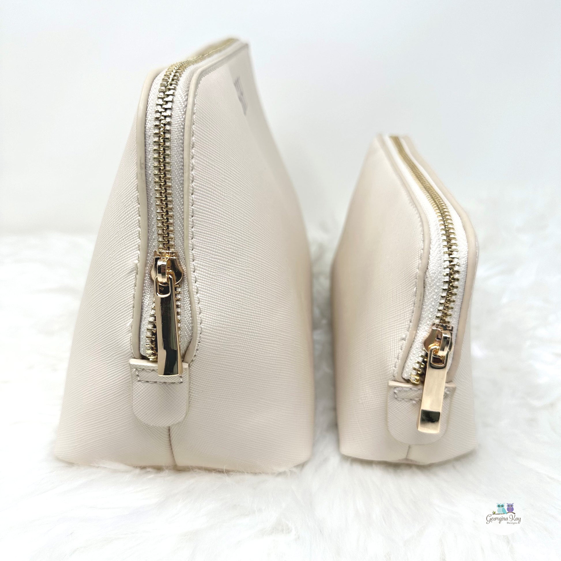 Two cream-colored cosmetic bags with gold zippers on a white background