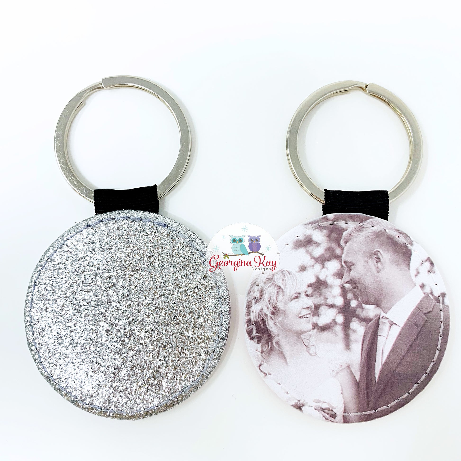 Two keychains, one glittery and one with a printed image of a couple, on a white background.